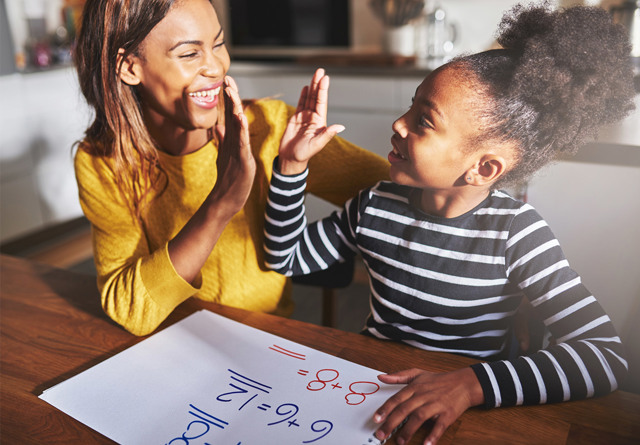 Mother and daughter practicing math and giving each  other a high five.